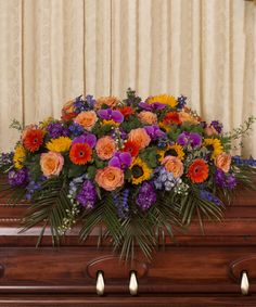 an arrangement of colorful flowers on top of a piano