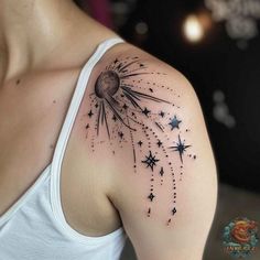 a woman with a tattoo on her shoulder that has stars in the sky flying from it