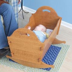 a baby laying in a wooden toy car