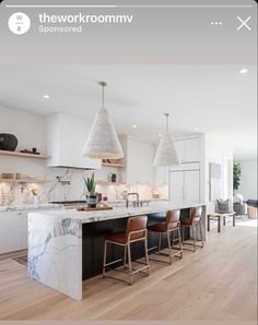 an image of a kitchen setting with marble counter tops and bar stools in the center