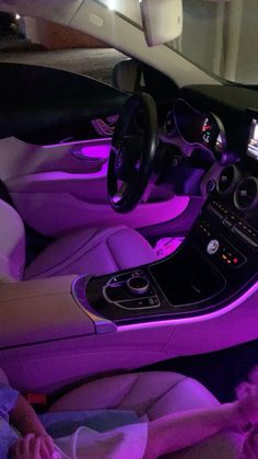 the interior of a car is lit up with purple lights and features an automatic steering wheel