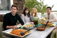 a group of people sitting around a table with food on it