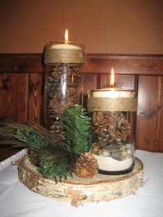 two glass jars filled with pine cones and candles