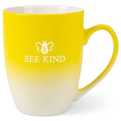 a yellow and white coffee cup with the words bee kind on it's side