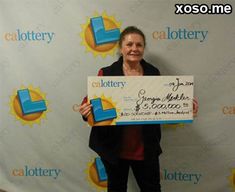 a woman holding up a large check for $ 1, 500 in front of a backdrop