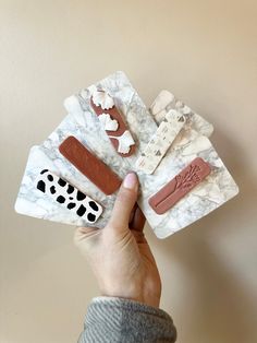 a person holding four pieces of marble with animal prints on them