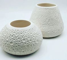 two white vases sitting next to each other