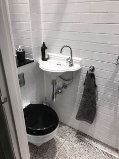 a black and white toilet sitting next to a sink