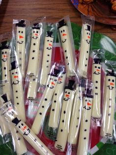 snowman candles are wrapped in plastic on a table