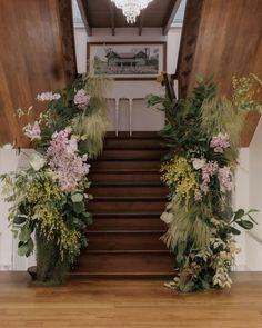 flowers and greenery are arranged on the stairs