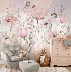 a room with pink flowers on the wall and a white chair in front of it