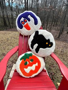 two stuffed pumpkins sitting on top of a red chair