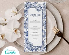 a wedding menu on a plate next to some white flowers and a glass of wine