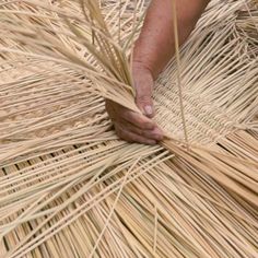 a person is working on some kind of straw structure that's made out of grass