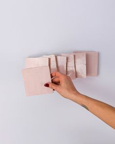 a hand is holding several pieces of pink paper