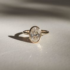 a diamond ring sitting on top of a white table next to a light colored surface