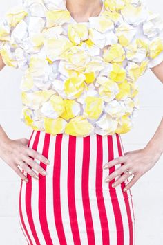 a woman with flowers on her head is wearing a striped skirt