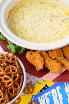 there is a bowl of soup and some pretzels on the plate next to it