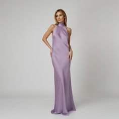 A captivating blend of elegance and allure, our Lylia Open Back Halter Dress exudes undeniable charm. Tailored with a flattering bias cut from lavender double silk satin, it drapes gracefully over the silhouette. The halter neckline delicately frames the shoulders, while the revealing back adds a note of sensuality. For a playful and feminine look, you can transform the silk tie neck into a chic bow, or you can let it drape loosely, adding a touch of laid-back sophistication to your ensemble.  W Elegant Lavender Gown For Gala, Elegant Lavender Floor-length Gown, Chic Purple Evening Gown, Elegant Lavender Maxi Dress For Evening, Elegant Lavender Evening Dress For Formal Events, Purple Silk Bias Cut Dress, Chic Purple Floor-length Gown, Lavender Sleeveless Evening Dress For Formal Occasion, Purple Party Dress With Bias Cut