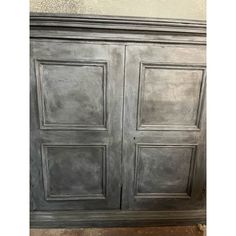 an old gray painted cabinet with two doors