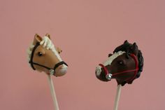 two brown and white horse head lollipops sitting on top of each other