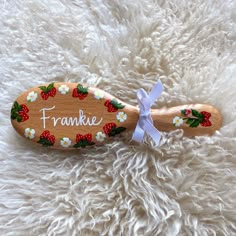 a wooden toothbrush with strawberries and flowers on it that says, frankie