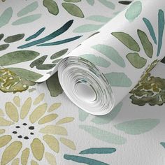 a wallpaper with green and yellow flowers on it's side, next to a roll of white paper