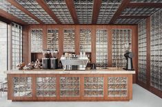 a coffee bar with glass block walls and wooden trimmings on the ceiling, along with an espresso machine