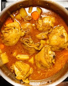 chicken stew with potatoes and carrots in a large pot on the stove, ready to be eaten