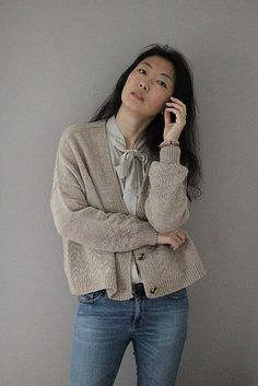 a woman is leaning against a wall and talking on her cell phone