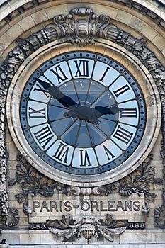 a large clock on the side of a building with roman numerals and ornate carvings