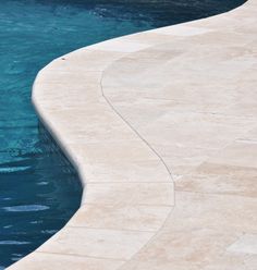 an empty swimming pool with blue water and no one in it or someone sitting on the edge