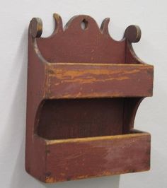 an old wooden shelf with two shelves attached to the wall and hanging from it's sides