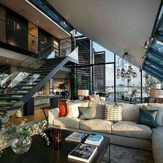 a living room filled with lots of furniture under a glass roof over looking the ocean