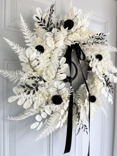 a white wreath with black and white flowers