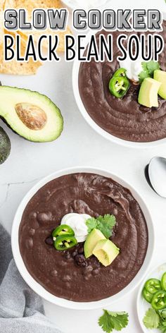 two bowls filled with black bean soup and topped with avocado