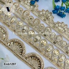 gold lace trims on white fabric with blue flowers in the background