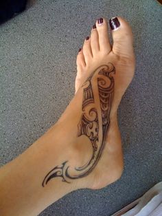 a woman's foot with a tattoo design on the top and bottom of it