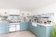 a kitchen with blue cabinets and marble counter tops