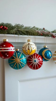 an assortment of christmas ornaments hanging from a mantel