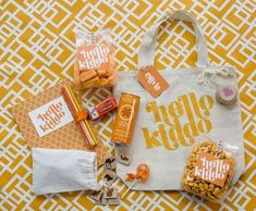 an orange and white bag with candy, candies, and other items on it