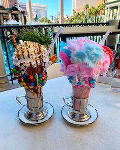 two ice cream sundaes are sitting on a table