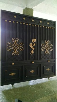 an ornate black and gold cabinet in a room