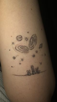 a tattoo on the leg of a person with saturn and stars in the sky above them