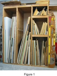 a bookcase filled with lots of books next to a red bin full of folders