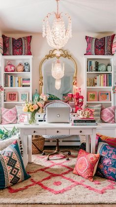 a living room filled with lots of colorful pillows and books on top of a white table