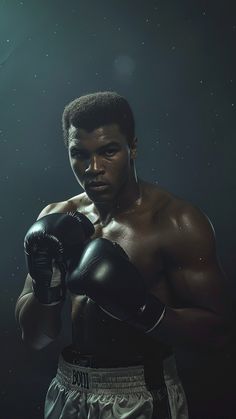 a young man wearing boxing gloves posing for a photo in front of a dark background