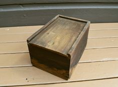 a wooden box sitting on top of a wooden floor next to a wall and door