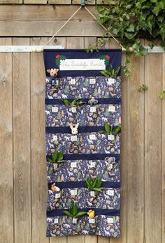 a towel hanging on a wooden fence with plants and pictures pinned to the wall behind it