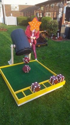 a person playing with some dices in the grass near a chair and lawn area